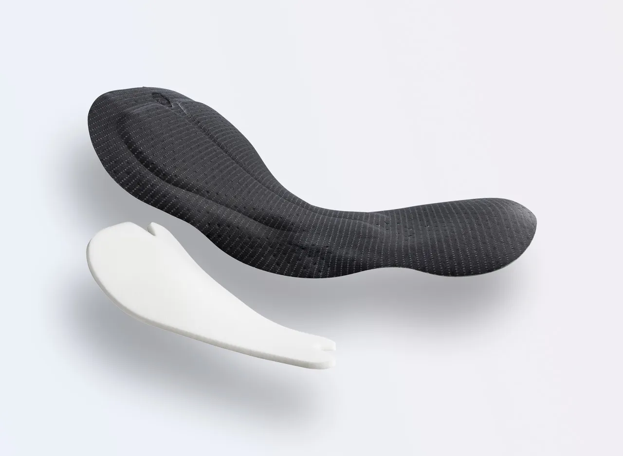 Dos almohadillas deportivas en diferentes colores, una en negro con un diseño texturizado y la otra en blanco con una forma simple.