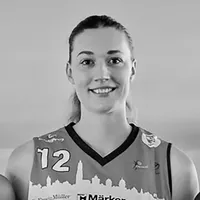 Una mujer con un jersey deportivo con el número 12 y un diseño de silueta de ciudad.