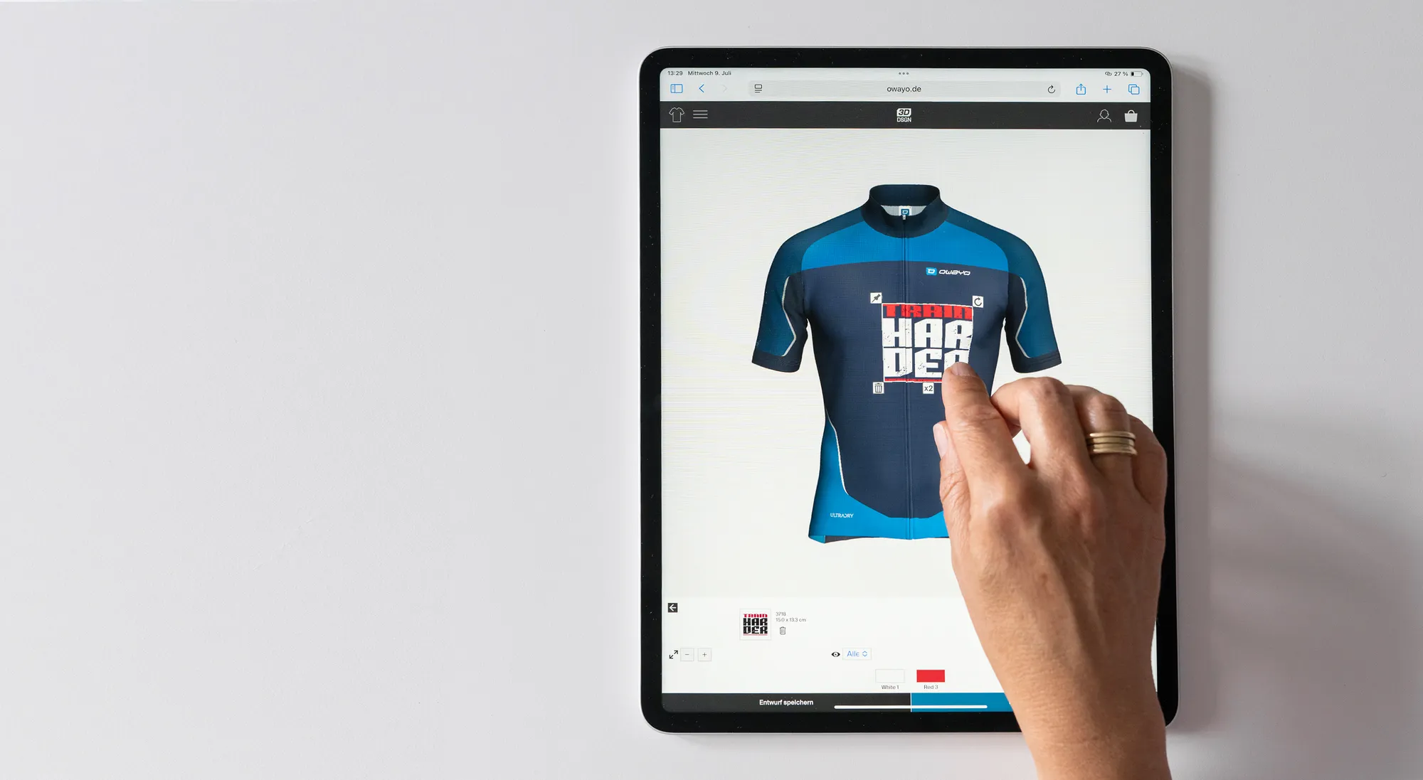 Una mano interactúa con una tableta que muestra una interfaz de diseño de maillot de ciclismo personalizado de owayo, editando un maillot azul con un diseño rojo y blanco.