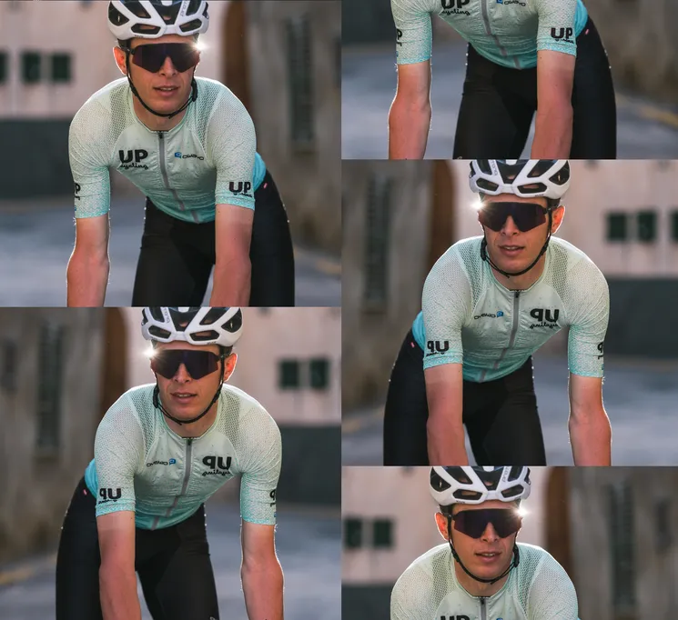 Un ciclista con una camiseta personalizada de color azul claro con el logo 'UP cycling' y 'owayo' en el pecho, pedaleando por una calle.